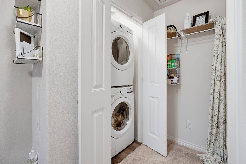 5525 Willamette Drive, Fort Worth, TX 76119 Enclosed laundry area featuring stacked front-load washer and dryer units