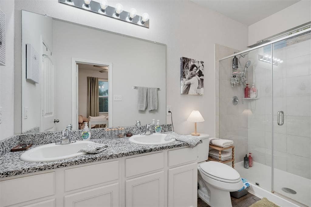 5525 Willamette Drive, Fort Worth, TX 76119 Dual vanity with undermount sinks, speckled countertop, and chrome fixtures