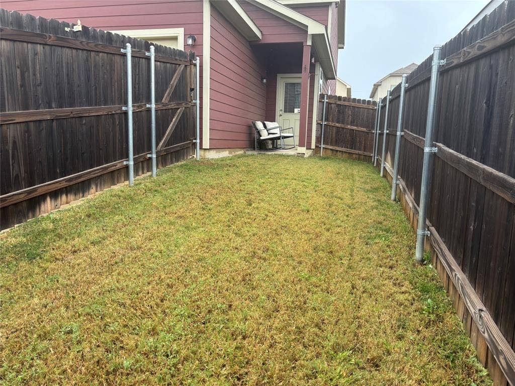 5525 Willamette Drive, Fort Worth, TX 76119 Private backyard space with wood fencing and a exterior door