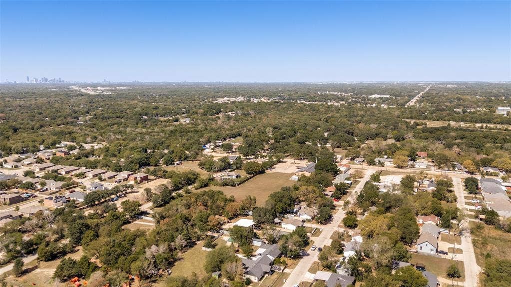 Aerial perspective of a tree-lined residential area with a distant city skyline