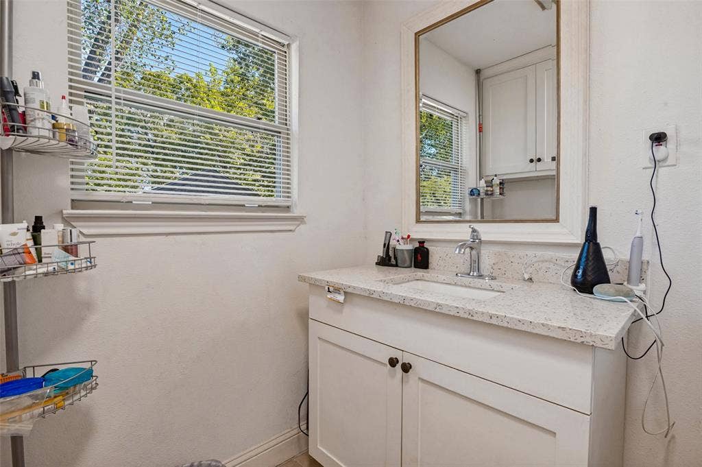 Vanity with an integrated sink, quartz countertop, and white shaker-style cabinetry
