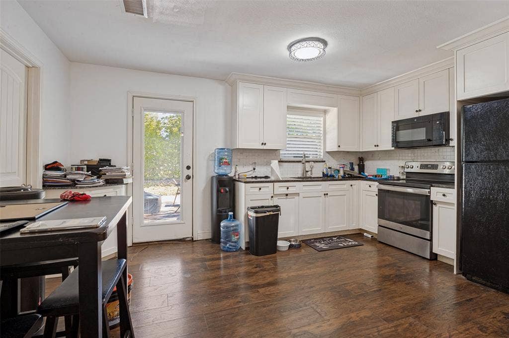 Kitchen featuring wood-finish flooring, white cabinetry, a stainless steel range, and an overhead microwave