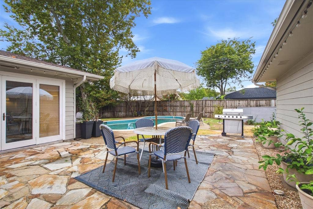 3612 Regent Drive, Dallas, TX 75229 Flagstone patio with a swimming pool, wood privacy fence, and white siding