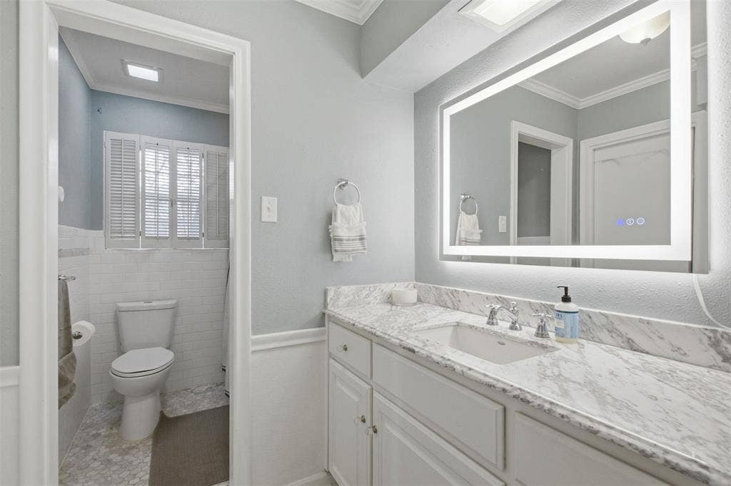 3612 Regent Drive, Dallas, TX 75229 White vanity with integrated sink, stone-finish countertop, and chrome faucet