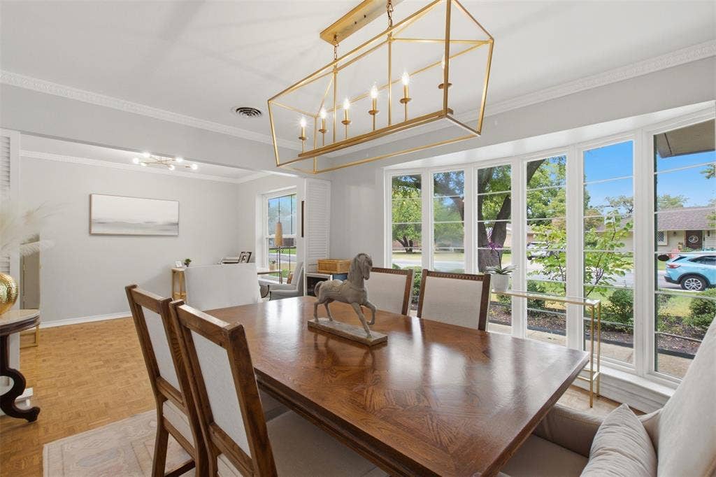 3612 Regent Drive, Dallas, TX 75229 Bay window with multiple panes, crown molding, wood-finish flooring, and a gold-tone geometric chandelier