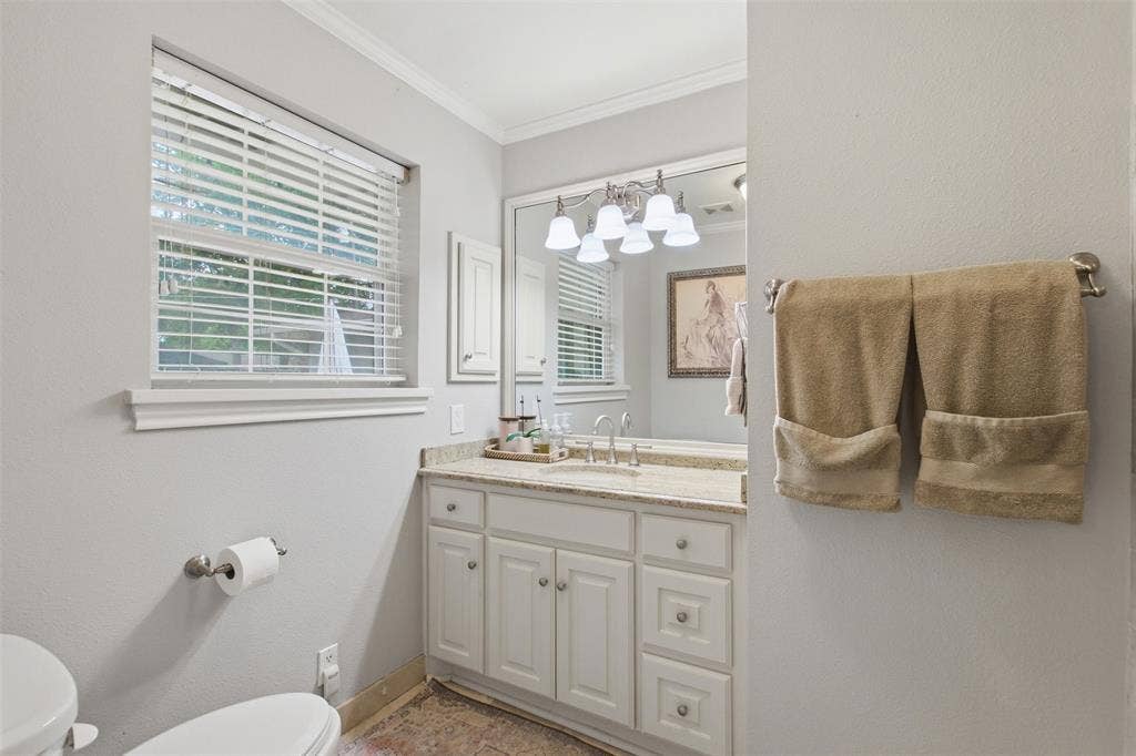 3612 Regent Drive, Dallas, TX 75229 Single vanity with a light-toned countertop, white cabinetry, and a framed mirror