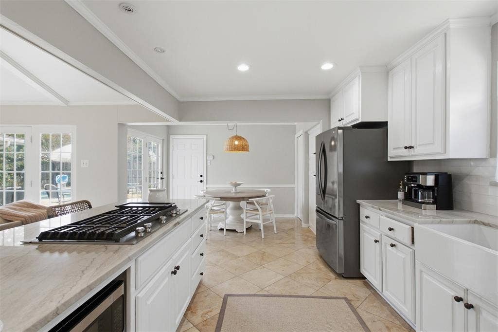 3612 Regent Drive, Dallas, TX 75229 Kitchen featuring a built-in cooktop on a central island, white cabinetry, integrated microwave, and a farmhouse sink