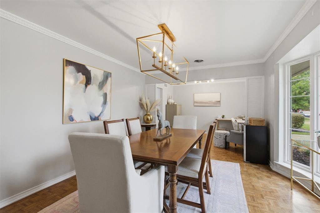 3612 Regent Drive, Dallas, TX 75229 Formal dining area featuring crown molding, a multi-pane window, wood-finish flooring, and a gold-tone linear chandelier
