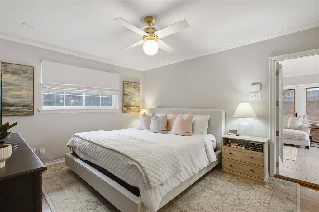 3612 Regent Drive, Dallas, TX 75229 Light-filled interior featuring a ceiling fan with integrated lighting, wood-finish flooring, and a window with a Roman shade