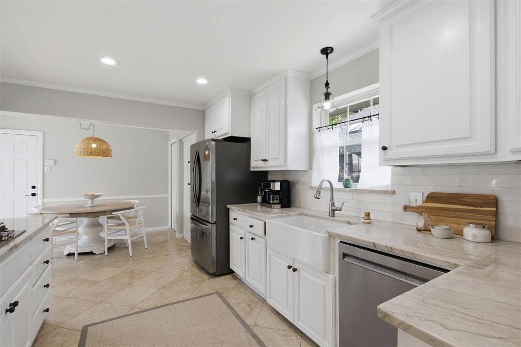 3612 Regent Drive, Dallas, TX 75229 Kitchen featuring white cabinetry, stone-finish countertops, subway tile backsplash, and a farmhouse-style sink