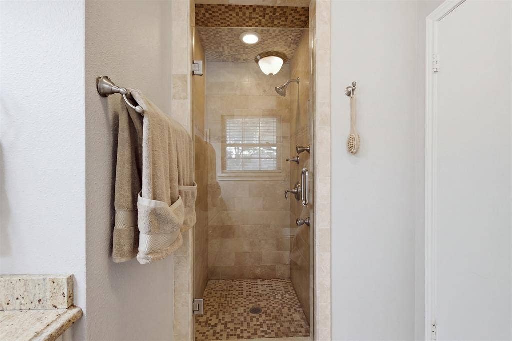 3612 Regent Drive, Dallas, TX 75229 Glass-enclosed shower with mosaic tile floor and ceiling, tiled walls, and multiple showerheads
