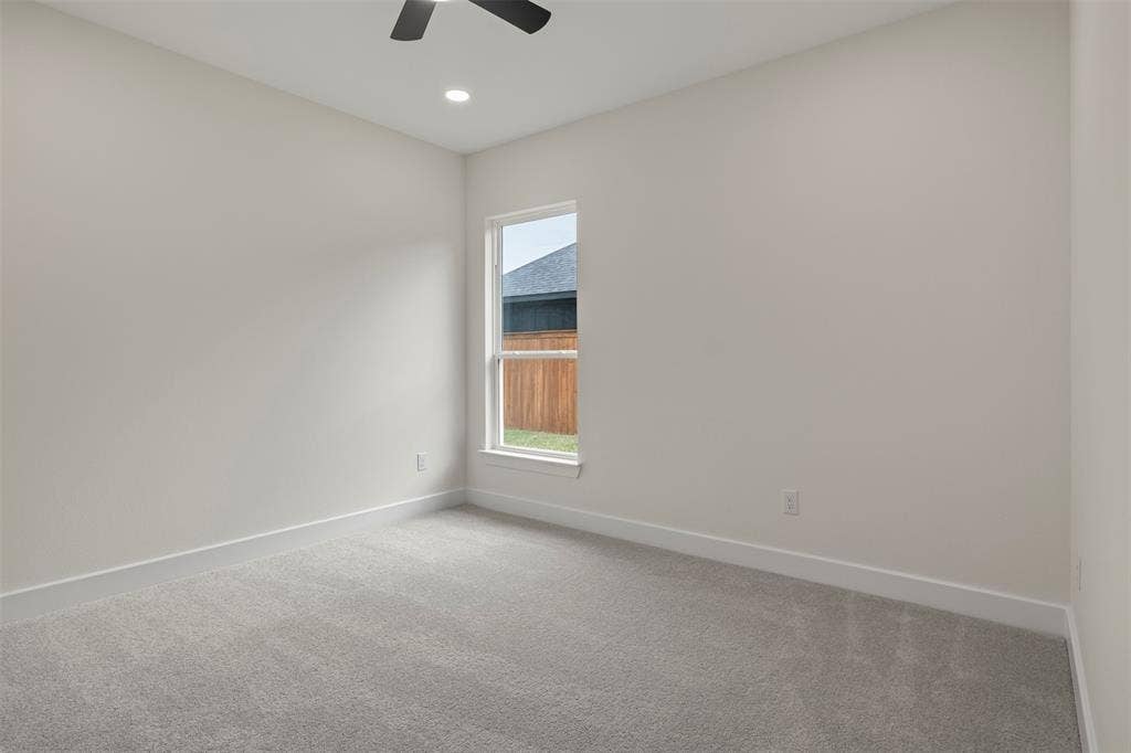 Neutral wall tones, gray carpeting, recessed lighting, and a ceiling fan