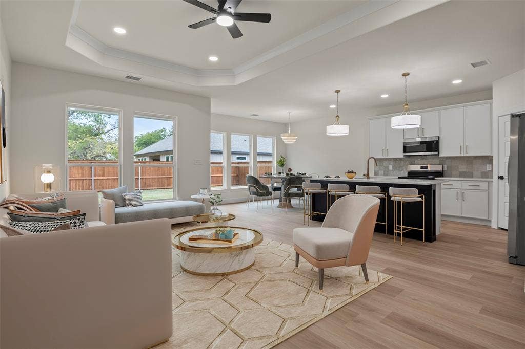 Recessed lighting, crown molding, wood-finish flooring, kitchen island with seating, and stainless steel appliances