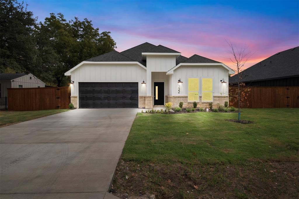 Contemporary exterior featuring vertical white siding, stone accents, and a dark asphalt shingle roof