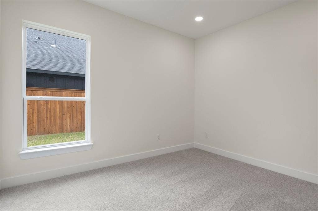 Recessed lighting, plush carpet flooring, white trim, and a double-hung window