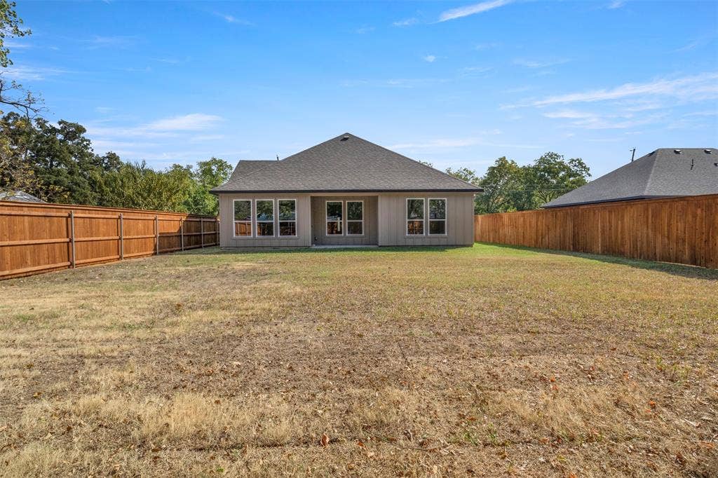 2507 Picadilly Boulevard, Mesquite, TX 75149 Expansive backyard with a full privacy fence, multiple large windows, and a neutral stucco exterior