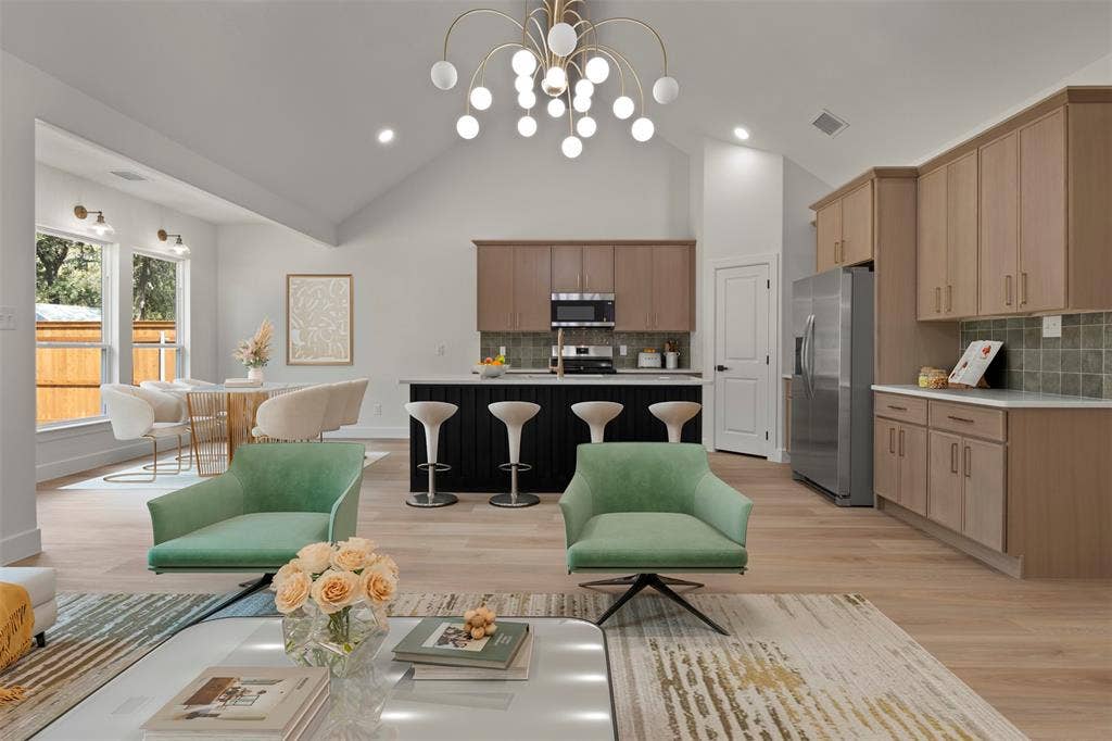 2507 Picadilly Boulevard, Mesquite, TX 75149 Vaulted ceilings with a statement chandelier, wood-finish flooring, two-tone kitchen cabinetry, an integrated kitchen island, and stainless steel appliances