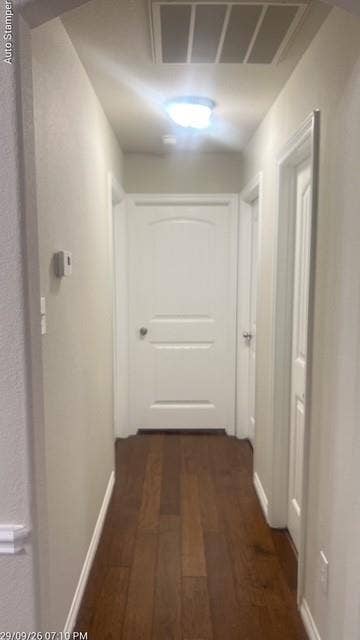 Wood-finish flooring, white paneled doors, ceiling-mounted light fixture, and white trim
