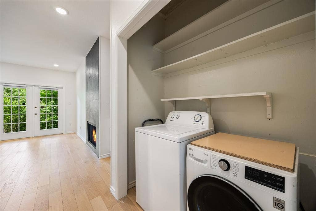 9801 Royal Lane, #701, Dallas, TX 75231 Recessed lighting, wood-finish flooring, two sets of double French doors, and a modern fireplace with dark tile surround