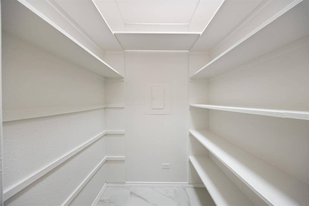 9801 Royal Lane, #701, Dallas, TX 75231 Recessed ceiling with integrated lighting, extensive built-in shelving, textured wall finish, and marble-look flooring