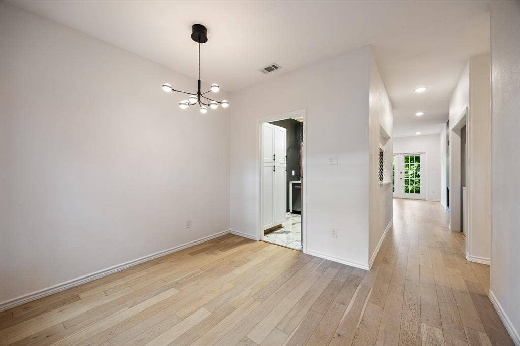 9801 Royal Lane, #701, Dallas, TX 75231 Recessed lighting, wood-finish flooring, contemporary chandelier, white cabinetry, and a glass-paneled exterior door