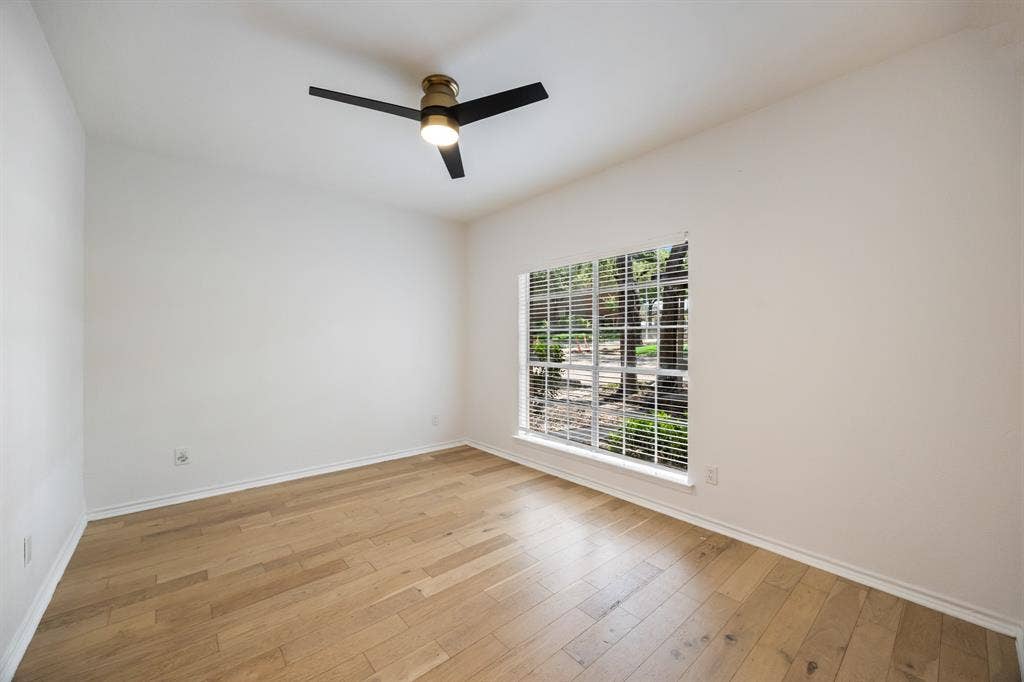 9801 Royal Lane, #701, Dallas, TX 75231 Light wood-finish flooring, white walls, and a modern ceiling fan with integrated lighting
