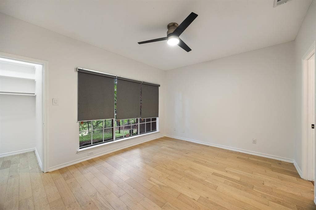9801 Royal Lane, #701, Dallas, TX 75231 Light wood-finish flooring, a contemporary ceiling fan, and a built-in closet with shelving