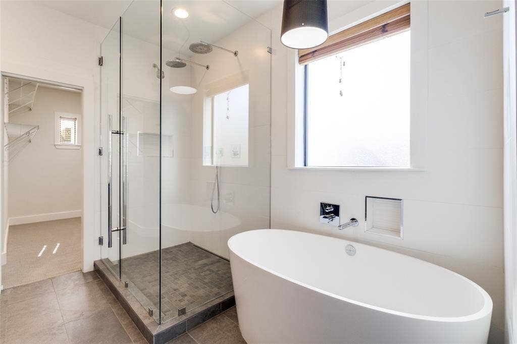 4211 Rawlins Street, #530, Dallas, TX 75219 Remodeled Primary Ensuite Bath with volcanic limestone soaking tub, frameless shower with Hansgrohe fixures