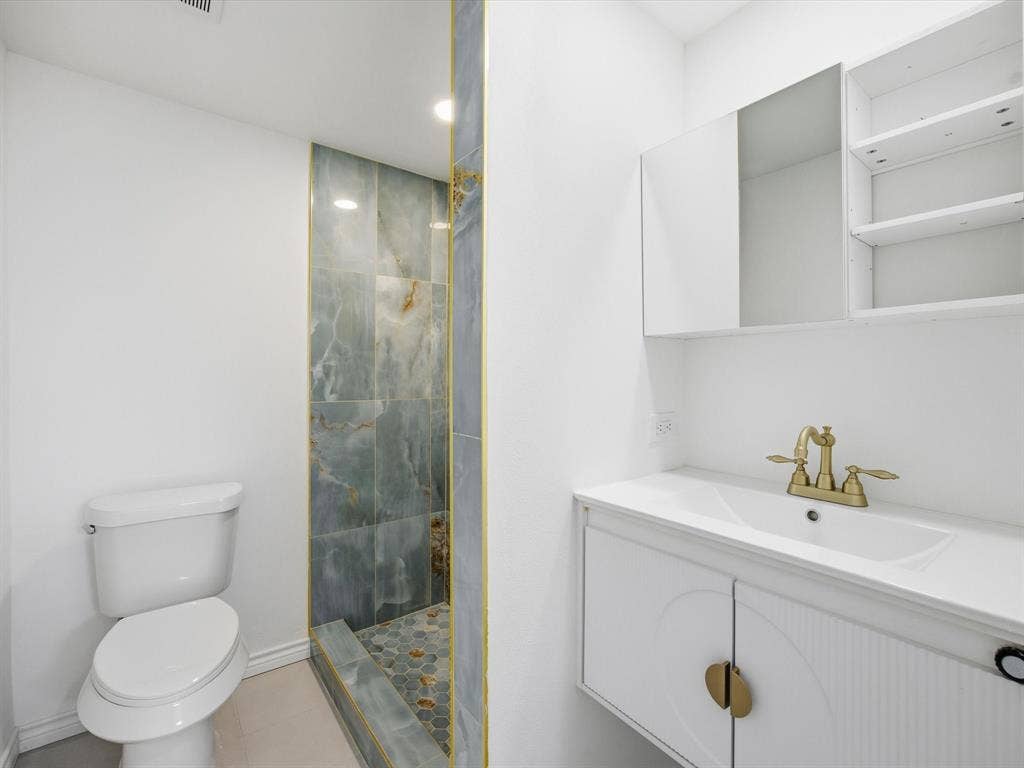 10270 Kilkenny Place, Dallas, TX 75228 Wall-mounted vanity with integrated sink, gold-finish faucet, and coordinating cabinet hardware