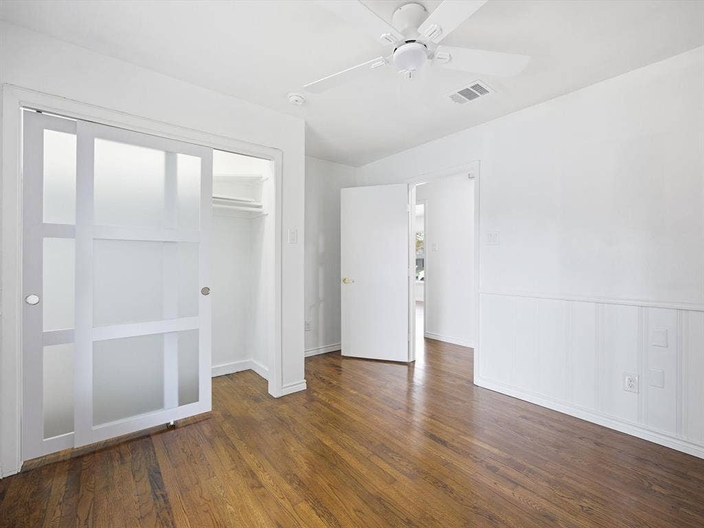 10270 Kilkenny Place, Dallas, TX 75228 Hardwood flooring, frosted glass sliding closet doors, wall paneling, and a ceiling fan with integrated lighting