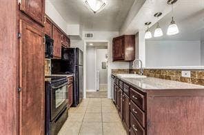5726 Marvin Loving Drive, #221, Garland, TX 75043 Kitchen featuring wood-finish cabinetry, tile flooring, stone-look countertops, and recessed lighting