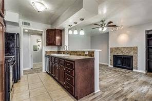 5726 Marvin Loving Drive, #221, Garland, TX 75043 Kitchen featuring wood-finish cabinetry, tile flooring, and a breakfast bar with stone-finish countertops