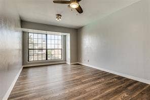 5726 Marvin Loving Drive, #221, Garland, TX 75043 Wood-finish flooring throughout, bay window with grid pattern, neutral wall tones, and a ceiling fan with integrated lighting