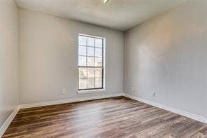 5726 Marvin Loving Drive, #221, Garland, TX 75043 Wood-finish flooring, white wall paint, window with grid panes, and crisp white trim