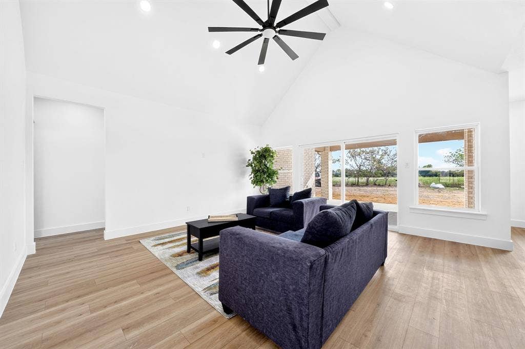 5731 Lewis Court, Athens, TX 75752 Vaulted ceiling with recessed lighting, wood-finish flooring, sliding glass patio doors, and a large window
