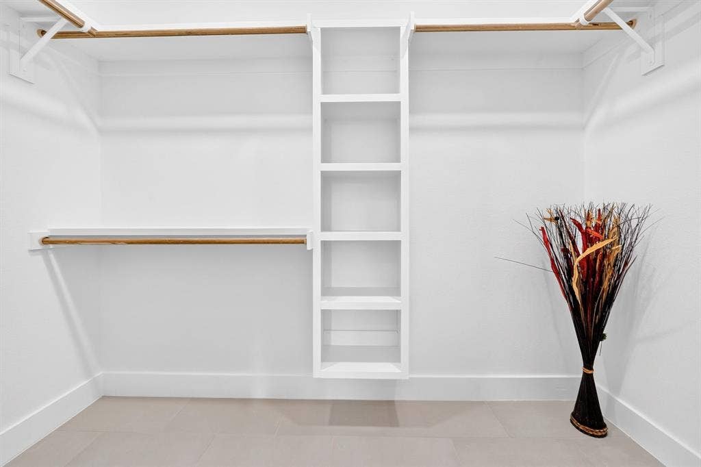 5731 Lewis Court, Athens, TX 75752 Built-in shelving unit, multiple hanging rods, and light-toned flooring