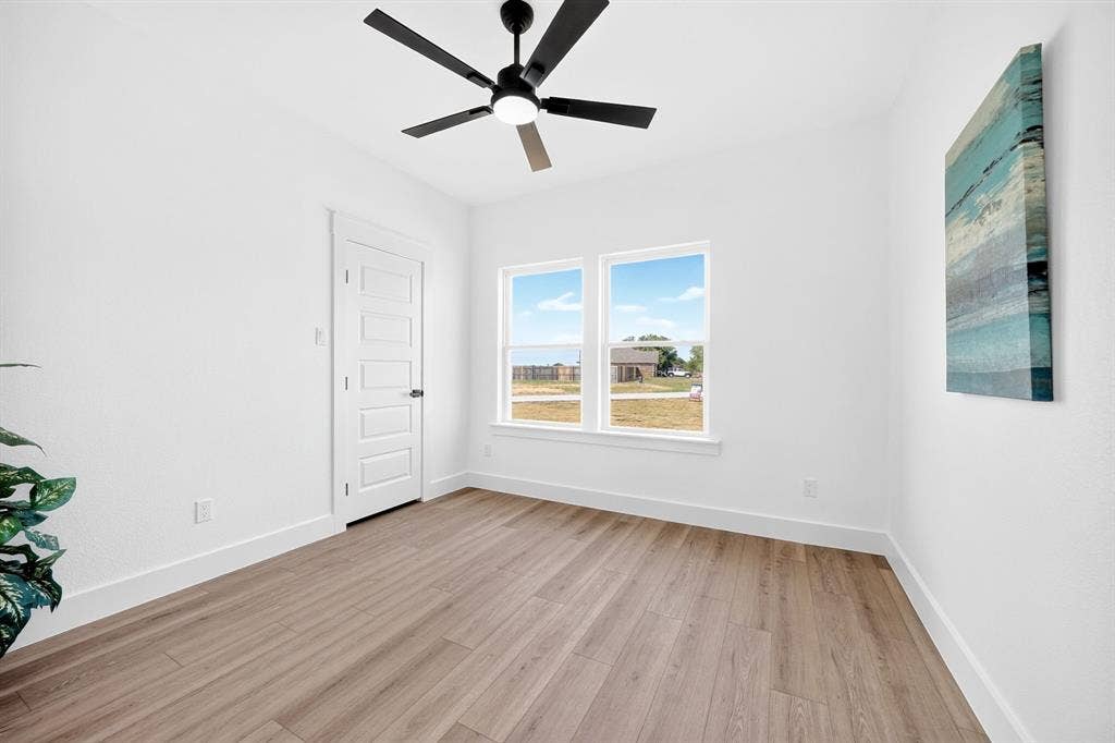 5731 Lewis Court, Athens, TX 75752 Wood-finish flooring, white walls, and a contemporary ceiling fan