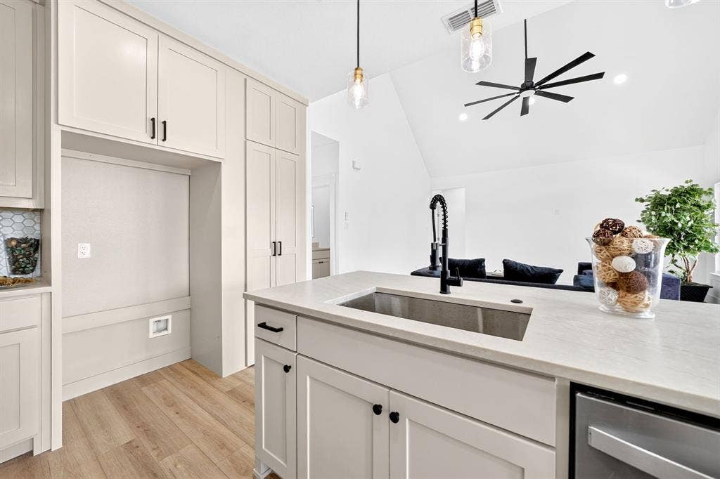 5731 Lewis Court, Athens, TX 75752 Kitchen featuring light-toned cabinetry, wood-finish flooring, a stainless steel sink with a matte black faucet, and pendant lighting