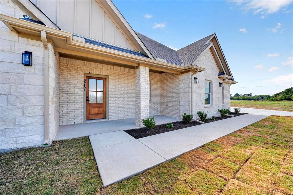 5731 Lewis Court, Athens, TX 75752 Stone and brick exterior with a covered entry and wood-finish front door