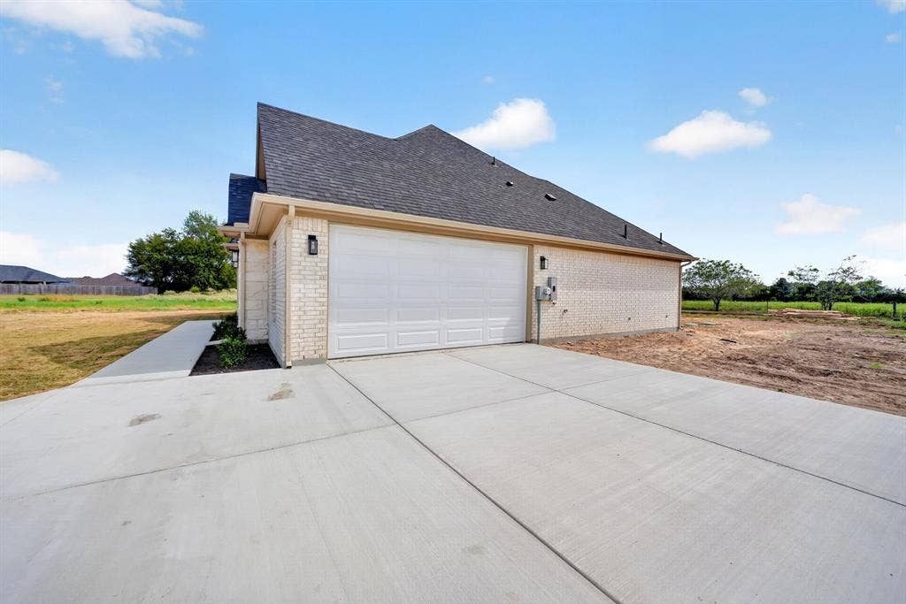 5731 Lewis Court, Athens, TX 75752 Brick exterior with dark shingle roof, attached garage, and paved driveway