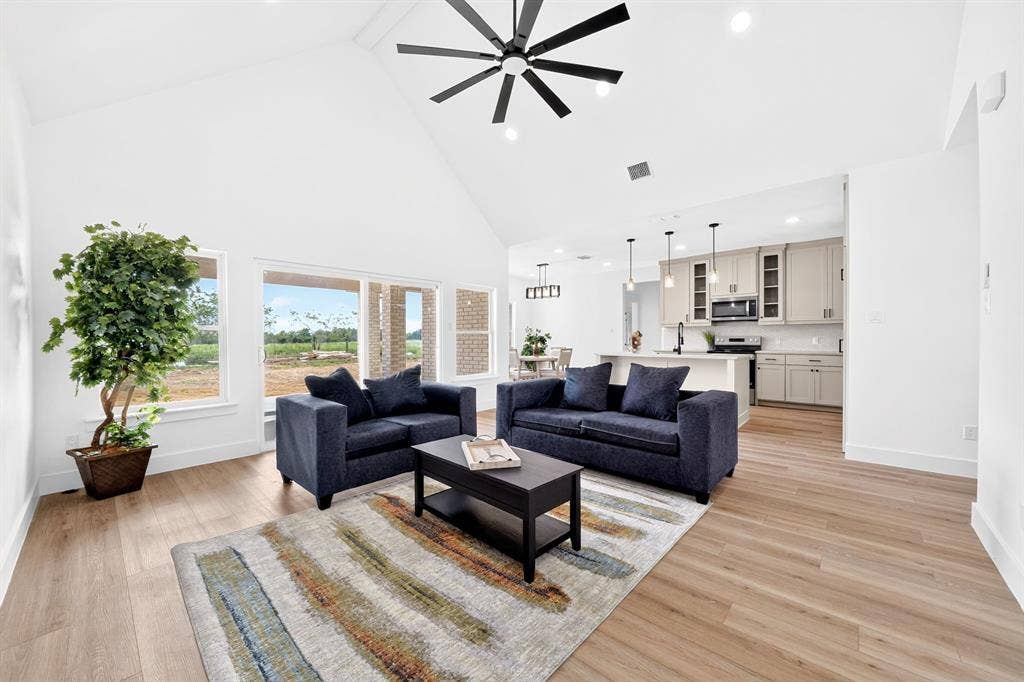 5731 Lewis Court, Athens, TX 75752 Vaulted ceiling with a contemporary ceiling fan, wood-finish flooring, ample natural light, and a kitchen featuring a central island and pendant lighting