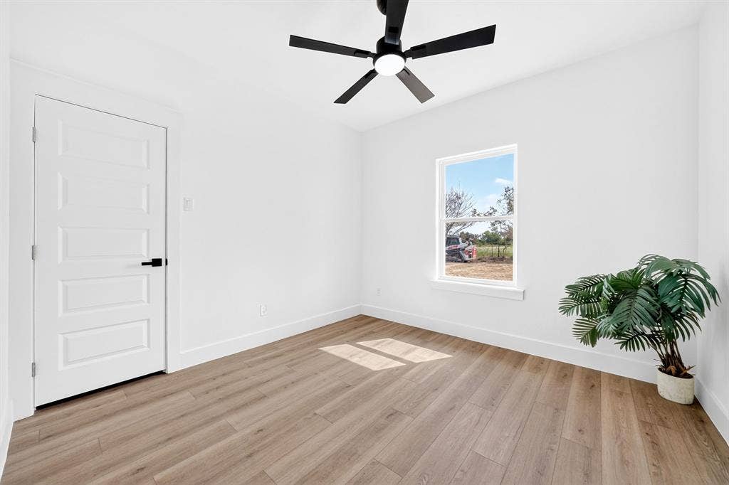 5731 Lewis Court, Athens, TX 75752 Wood-finish flooring, white walls, and a contemporary ceiling fan with integrated lighting