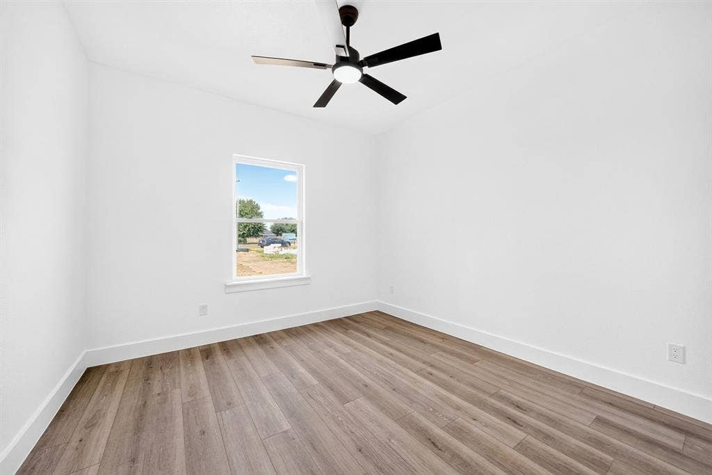5731 Lewis Court, Athens, TX 75752 Wood-finish flooring, white walls, and a contemporary black ceiling fan with integrated lighting