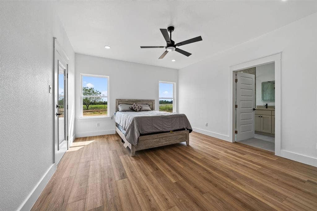 5731 Lewis Court, Athens, TX 75752 Wood-finish flooring throughout, bright white walls, and a contemporary ceiling fan