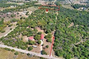 6630 Prather Road, Springtown, TX 76082 Expansive land parcel featuring multiple structures, mature trees, and direct road frontage
