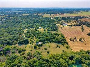 6630 Prather Road, Springtown, TX 76082 Expansive rural acreage featuring mature tree-lined boundaries, pastoral open fields, and a winding waterway
