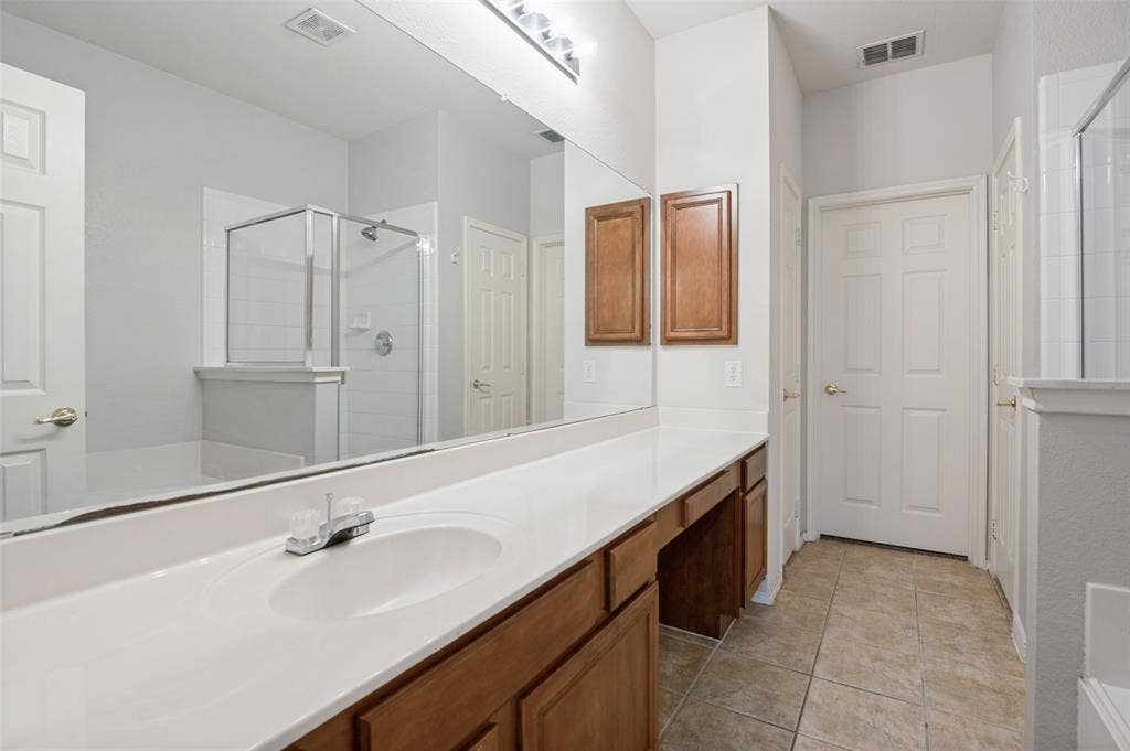 3236 Twist Trail, Plano, TX 75093 Extended vanity with integrated sink, wood-finish cabinetry, and a full-width mirror