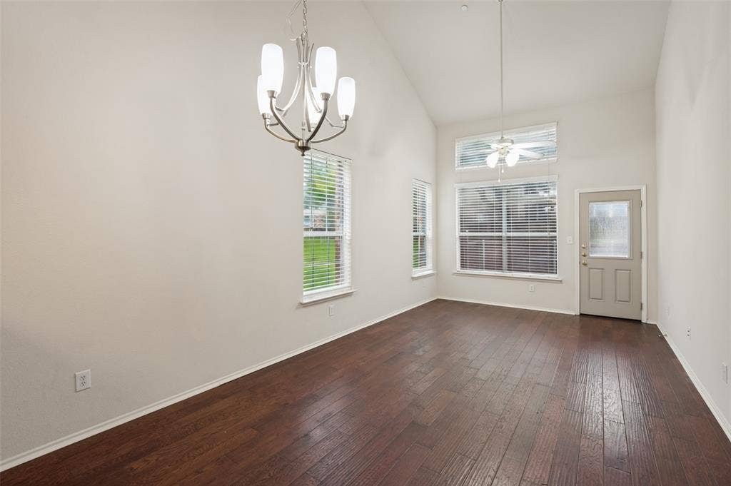 3236 Twist Trail, Plano, TX 75093 Vaulted ceiling with a chandelier, wood-finish flooring, and multiple windows with blinds