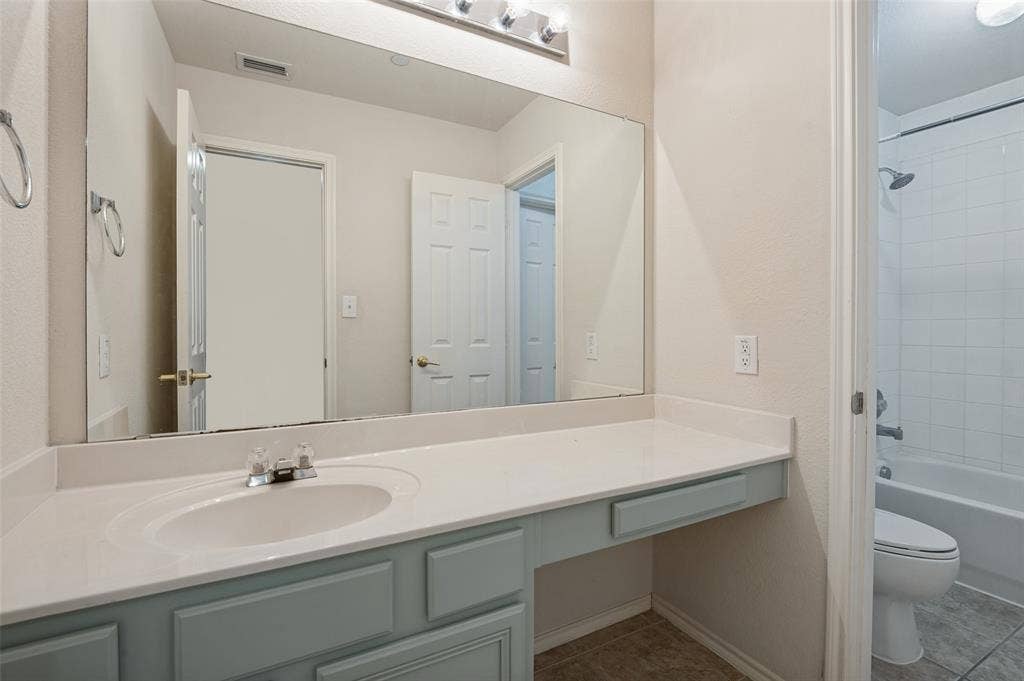 3236 Twist Trail, Plano, TX 75093 Vanity with an integrated sink and light blue cabinetry, chrome faucet, expansive wall-mounted mirror, and overhead vanity lighting