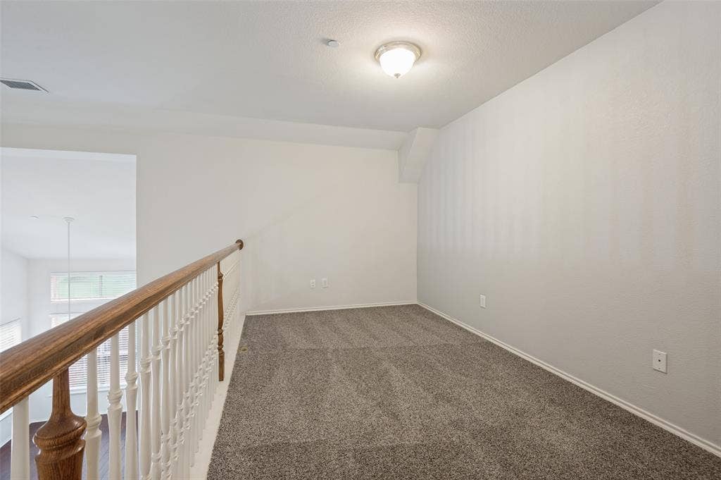 3236 Twist Trail, Plano, TX 75093 Carpeted loft area with a wood handrail, white balusters, and a semi-flush mount light fixture